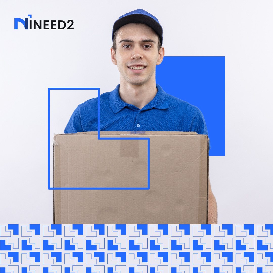 An INEED2 tasker in uniform carrying a moving box.